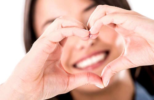 Woman making a heart shape with her hands - isolated over white Woman making a heart shape with her hands - isolated over white